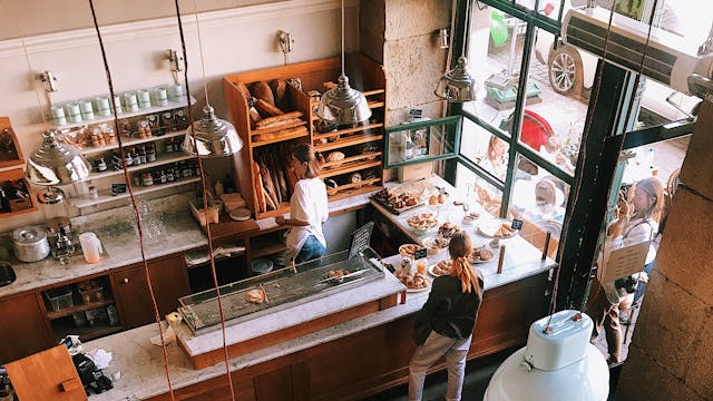 A vibrant aerial view of a busy cafe in Kraków, showcasing patrons enjoying baked goods and coffee.
