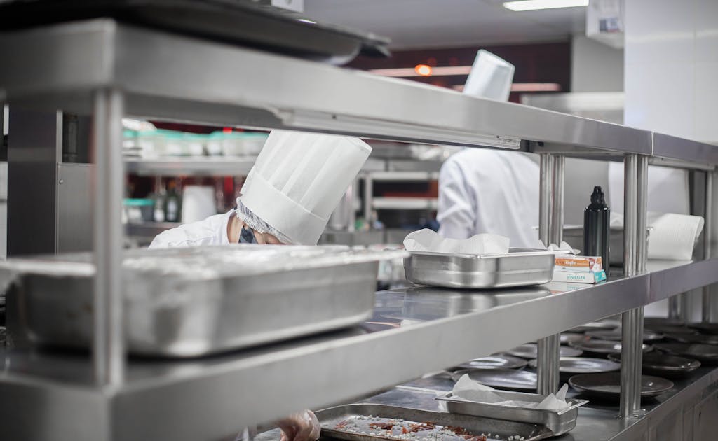 Chefs working diligently in a modern stainless steel kitchen, preparing delicious dishes.