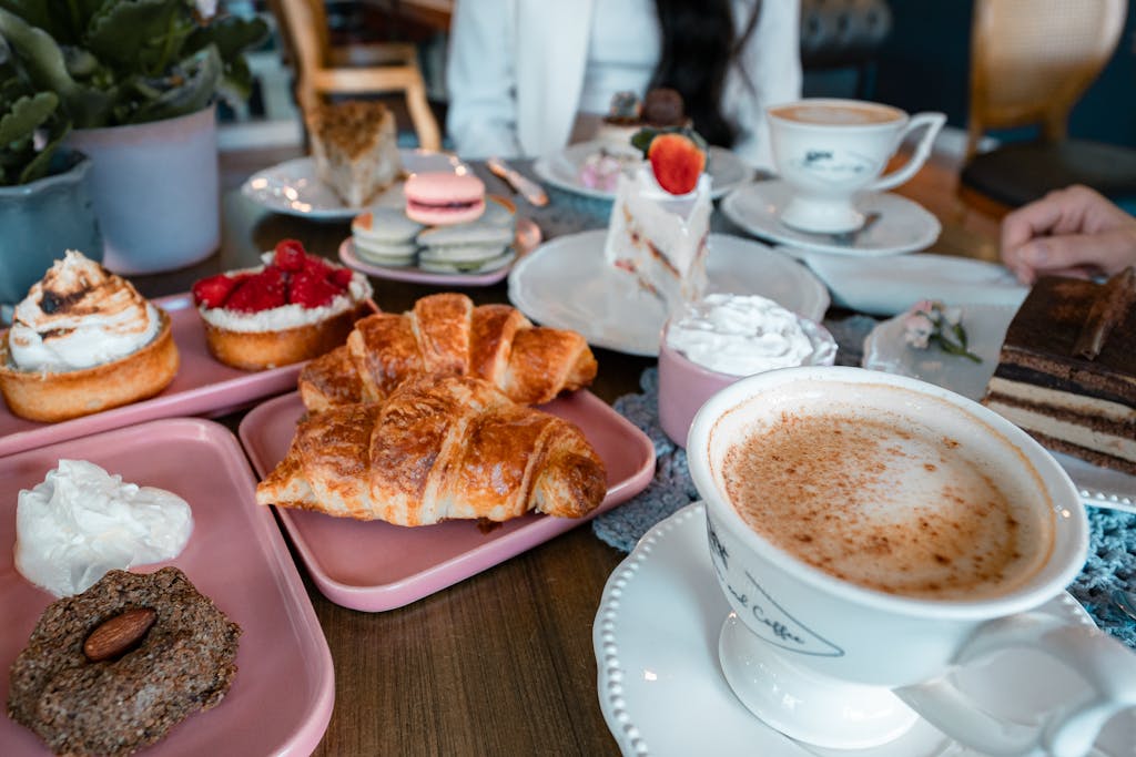 Delightful brunch table setup with croissants, coffee, and assorted pastries indoors.