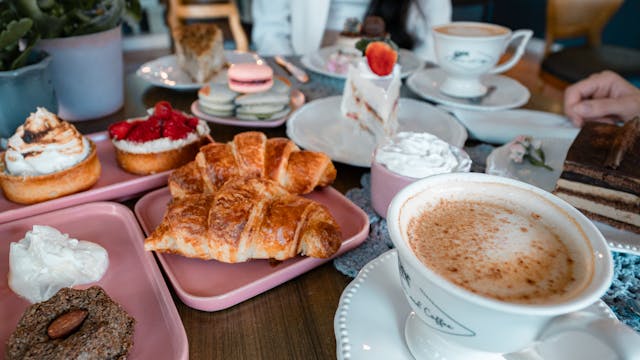 Delightful brunch table setup with croissants, coffee, and assorted pastries indoors.