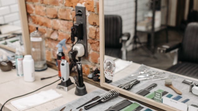 Neatly arranged barber tools in a stylish salon setting with brick wall.